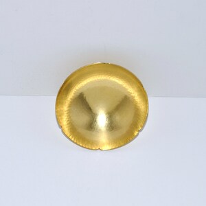 Puede incluir: Un cuenco de metal de color dorado con un acabado martillado y un borde festoneado.