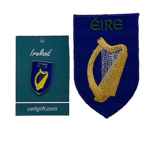 Puede incluir: Un pin de arpa irlandesa azul y dorado y un parche bordado azul y dorado con la palabra "ÉIRE" en letras verdes. Ambos artículos presentan el arpa irlandesa, un símbolo nacional de Irlanda.