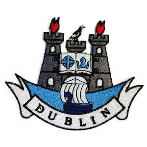 May include: Embroidered patch featuring the coat of arms of Dublin, Ireland. The patch depicts a castle with two towers, a ship, a book, and a bird. The words "DUBLIN" are written in a white banner.