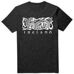 May include: A charcoal grey short-sleeve t-shirt featuring a white graphic print of an intricate Celtic-style knotwork animal design. Below the graphic, the word IRELAND is printed in a bold, stylized white font across the chest area.