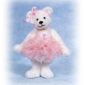 May include: A white teddy bear wearing a pink tulle tutu and a pink bow. The bear has black eyes and a black nose.