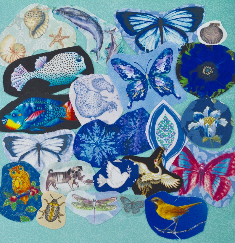 May include: A collection of fabric cutouts featuring various designs, including butterflies, fish, a whale, a pug, and a bird. The cutouts are primarily blue, with accents of yellow, red, and white. The background is a light blue patterned fabric.