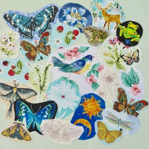 May include: A collection of fabric patches featuring various nature-inspired designs. The patches include butterflies, a bird, a frog, a deer, flowers, and celestial elements. The color palette includes blues, greens, yellows, and browns.