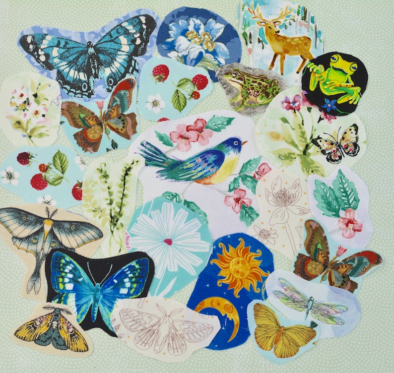 May include: A collection of fabric patches featuring various nature-inspired designs. The patches include butterflies, a bird, a frog, a deer, flowers, and celestial elements. The color palette includes blues, greens, yellows, and browns.