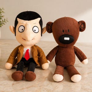 Può includere: Due peluche: uno che assomiglia a un personaggio con giacca marrone e cravatta rossa, e l'altro un orso marrone con dettagli bianchi. I giocattoli sono uno accanto all'altro, mostrando le loro diverse caratteristiche e design.