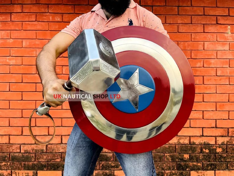 May include: A person holding a silver Mjolnir hammer and a red, white, and blue Captain America shield. The shield has a large silver star in the center.