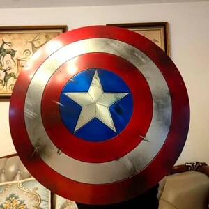 May include: A red, white, and blue Captain America shield with a large, white star in the center. The shield has a distressed, worn look.