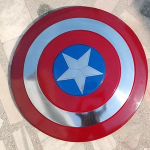 May include: A red, white, and blue Captain America shield with a silver rim. The shield has a five-pointed star in the center.