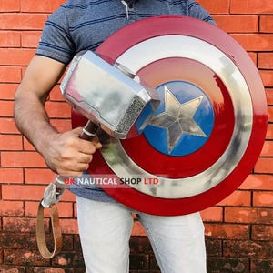 May include: A person holding a silver Thor's hammer and a red, white, and blue Captain America shield. The shield has a star in the center.