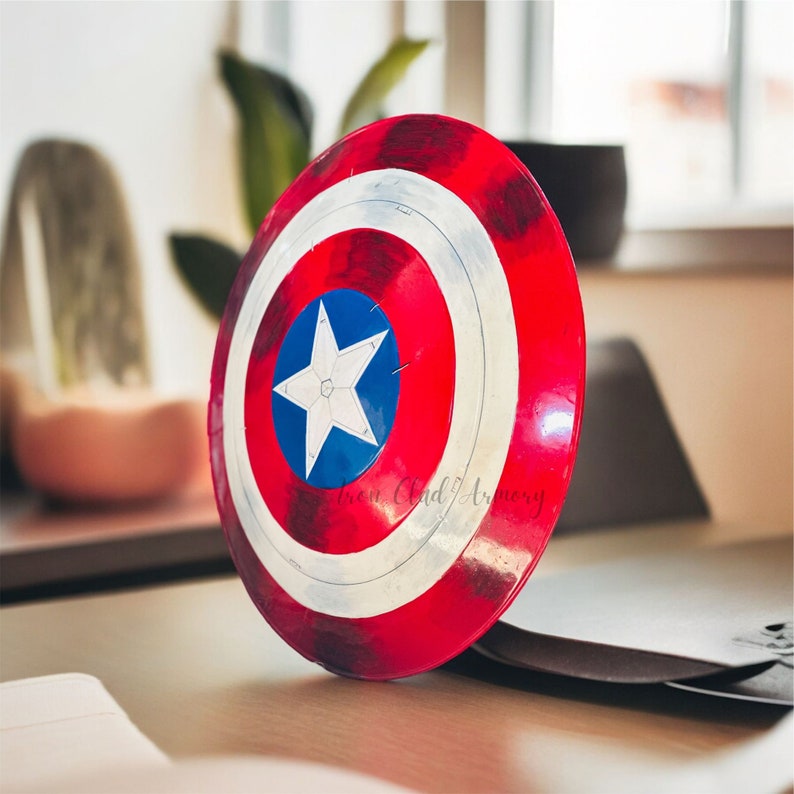 Pu&ograve; includere: Uno scudo di Capitan America rosso, bianco e blu con una stella a cinque punte al centro. Lo scudo &egrave; fatto di un materiale lucido e riflettente.