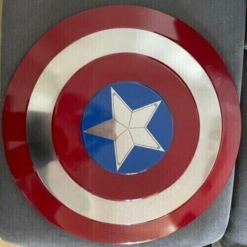 May include: A red, white, and blue Captain America shield with a silver metal rim. The shield has a five-pointed star in the center.