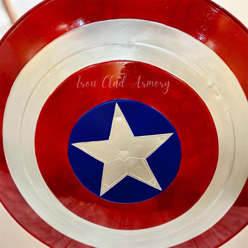 Pu&ograve; includere: Uno scudo di Capitan America rosso, bianco e blu con una stella bianca al centro. Lo scudo ha il testo "Iron Clad Armory".