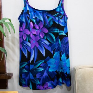 Puede incluir: Un vestido sin mangas de estampado floral azul y morado con cuello redondo y tirantes ajustables.