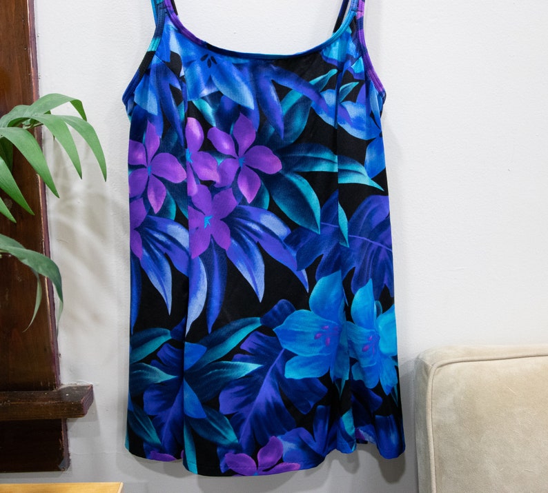 Puede incluir: Un vestido sin mangas de estampado floral azul y morado con cuello redondo y tirantes ajustables.