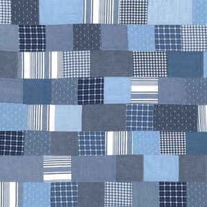 May include: A patchwork quilt made of various shades of blue denim fabric. The quilt is made up of squares and rectangles of different sizes and patterns, including stripes, polka dots, and plaid.