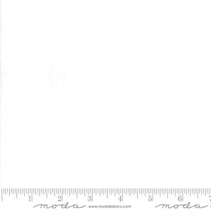 May include: A solid white fabric swatch featuring a printed ruler along the bottom edge that measures up to 7 inches. The text "moda" and "www.modafabrics.com" is printed in black along the bottom edge of the white fabric material.