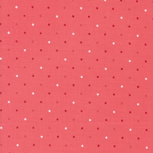 May include: A pink fabric with a white and red polka dot pattern.