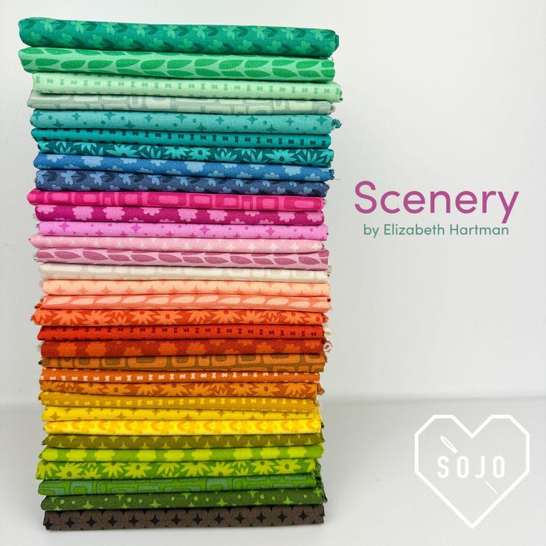 May include: A tall stack of folded fabric squares featuring a diverse range of colors including green, blue, pink, orange, yellow, and brown. Each piece of fabric displays a unique geometric or floral pattern. The text Scenery by Elizabeth Hartman is visible.