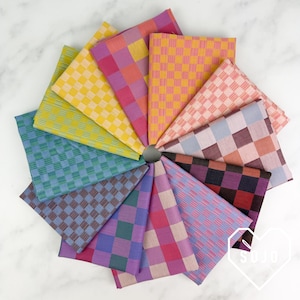 May include: A collection of twelve folded fabric squares arranged in a circular fan pattern. Each square features a distinct two-tone checkered pattern in various color combinations including yellow, green, blue, purple, pink, orange, and brown.