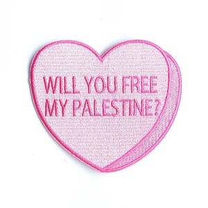 May include: Pink heart-shaped patch with the text "Will you free my Palestine?" embroidered in pink.