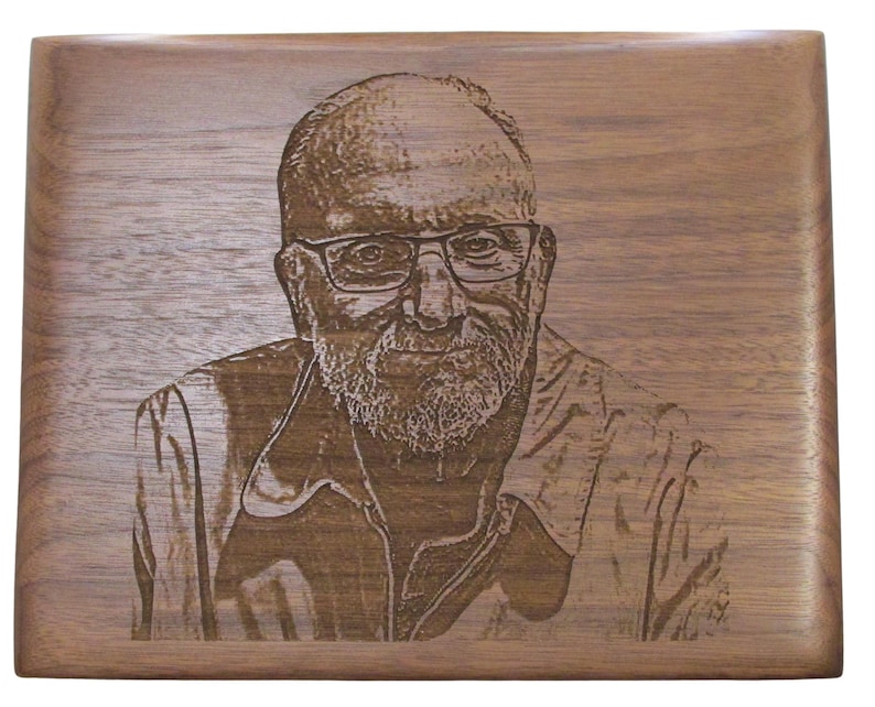 May include: A wood plaque with a laser engraved image of a man with a beard and glasses. The man is wearing a jacket and has a serious expression.