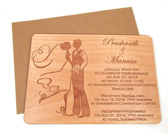 May include: A wooden wedding invitation with an engraved image of a bride and groom. The invitation reads "Prashanth & Manasa Joyfully invite you to celebrate their marriage on Aug 20, 2014 between 10 and 11 AM at Saraswathi Convention Center, Bangalore. Reception (Bangalore): On Aug 19, 2014, 7PM onwards at Saraswathi Convention Center. Reception (Hyderabad): On Aug 31, 2014, 7PM onwards at Hotel Surabhi Pride."
