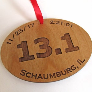 May include: Wooden oval-shaped ornament with the text "11/25/17 13.1 Schaumburg, IL 2:21:01" engraved on it.