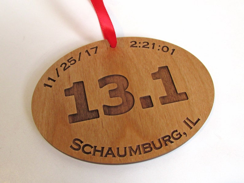 May include: Wooden oval-shaped ornament with the text "11/25/17 13.1 Schaumburg, IL 2:21:01" engraved on it.