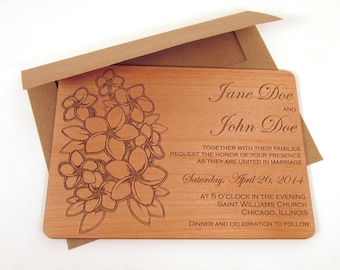 May include: A wooden wedding invitation with a floral design and the text "Jane Doe and John Doe" with the wedding date "Saturday, April 26, 2014".
