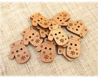 May include: A group of wooden buttons shaped like mittens with a snowflake design. The buttons are a light brown color and have two holes each.