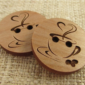 May include: Two wooden buttons featuring a coffee cup design. The buttons are brown and have a heart-shaped steam rising from the cup. One button has a shamrock design below the cup.