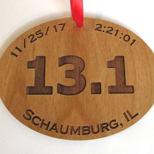 May include: A wooden oval-shaped medal with the text "11/25/17 2:21:01 13.1 Schaumburg, IL" engraved on it.