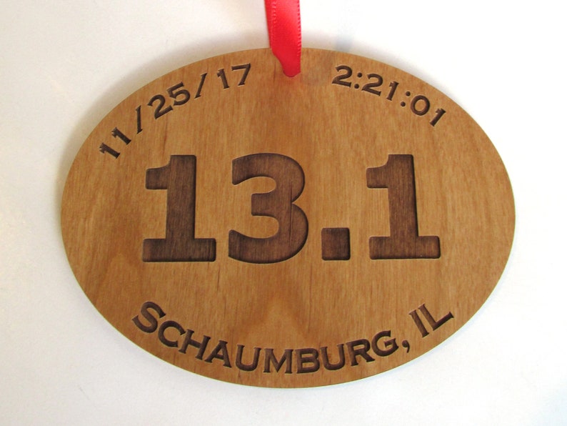 May include: A wooden oval-shaped medal with the text "11/25/17 2:21:01 13.1 Schaumburg, IL" engraved on it.