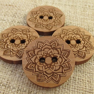 May include: Four wooden buttons with a mandala design. The buttons are brown and have two holes each.