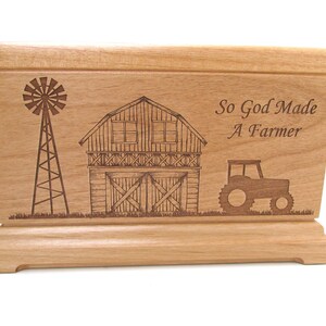 May include: Wooden box with an engraved design of a barn, windmill, and tractor. The text "So God Made A Farmer" is engraved on the box.