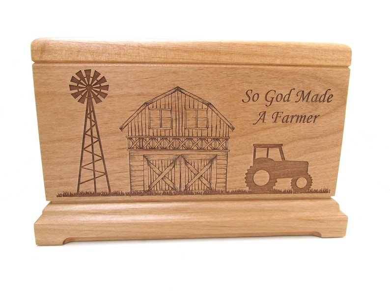 May include: Wooden box with an engraved design of a barn, windmill, and tractor. The text "So God Made A Farmer" is engraved on the box.
