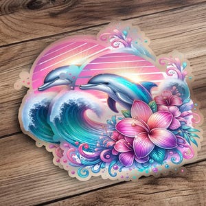 Pode incluir: Um adesivo com dois golfinhos saltando sobre uma onda com flores rosa e roxas e um fundo de p&ocirc;r do sol.