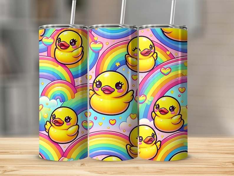 May include: A stainless steel tumbler with a colorful design featuring yellow rubber ducks and rainbows. The tumbler has a pink background with white hearts and stars.
