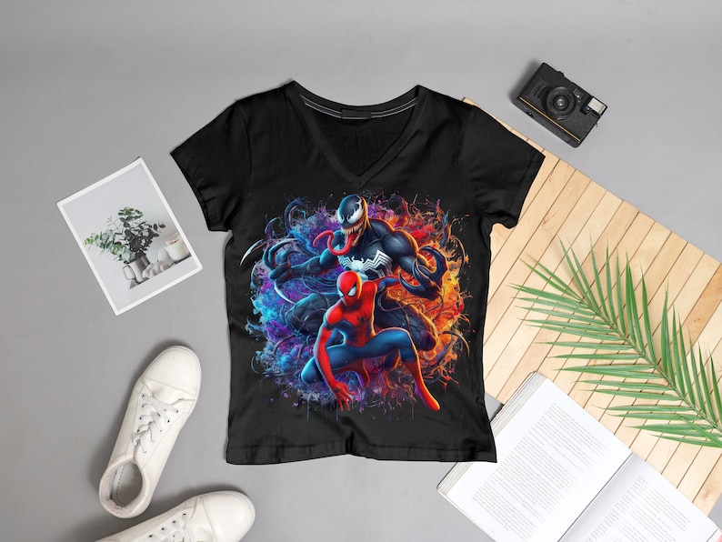 May include: Black t-shirt with a colorful graphic print of Spider-Man and Venom. The graphic features a blue and purple background with orange and yellow accents.
