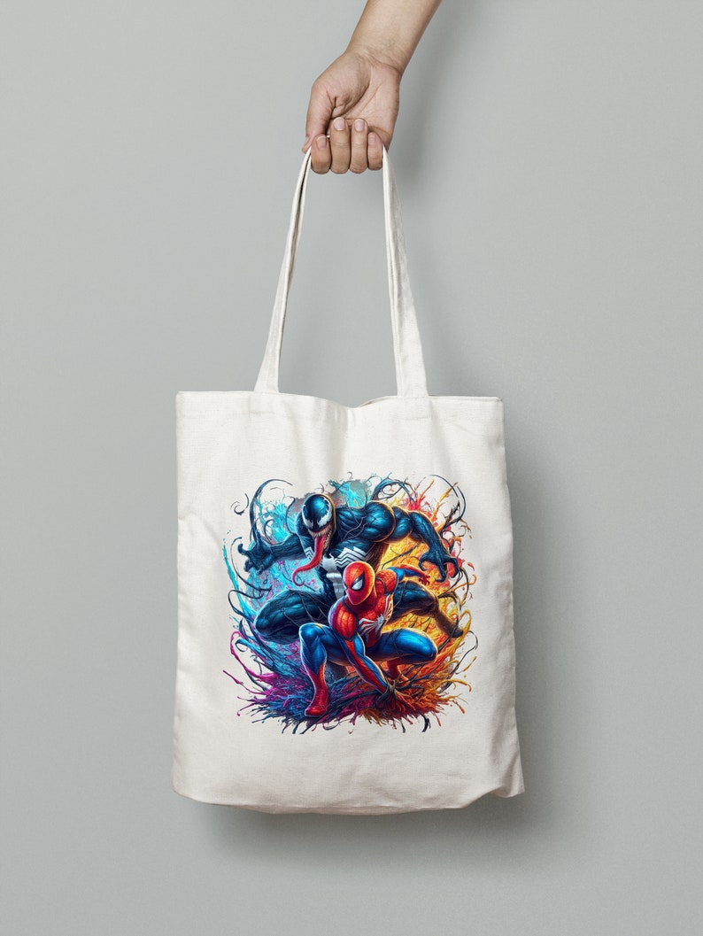 May include: A white canvas tote bag with a colorful graphic print of Spider-Man and Venom. The image features the two characters in a dynamic pose with splashes of blue, red, orange, and yellow paint.