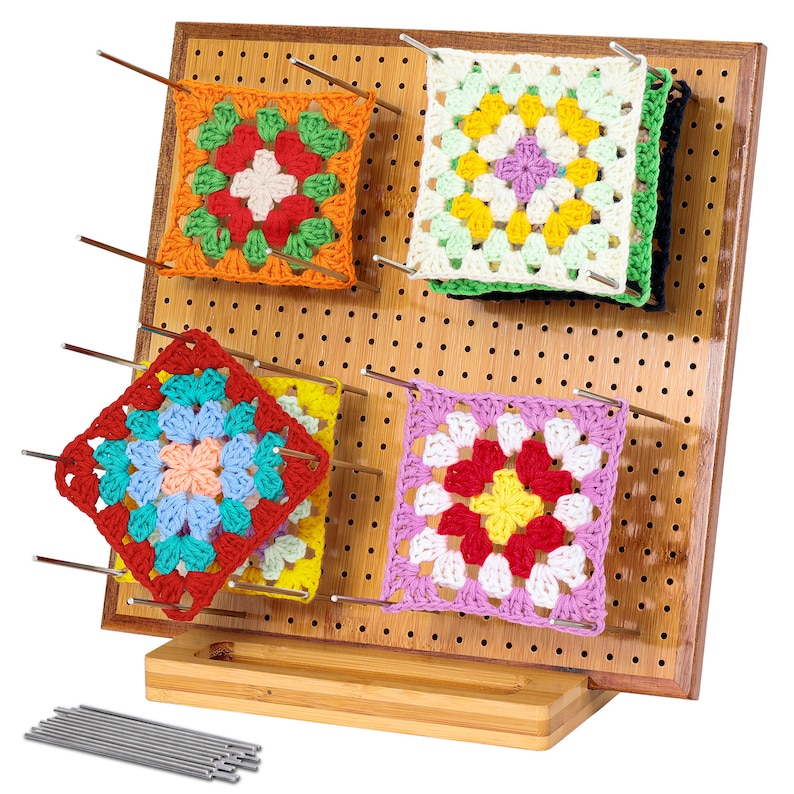 May include: A bamboo crochet project display stand with four colourful crochet squares, each with a different pattern, displayed on the stand. The stand has a pegboard design and comes with 12 metal pins.