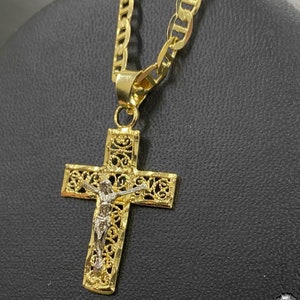 May include: A gold chain necklace with a detailed gold and silver filigree cross pendant featuring a figure of Jesus Christ.