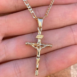 May include: A gold chain necklace with a gold Jesus on the cross pendant.