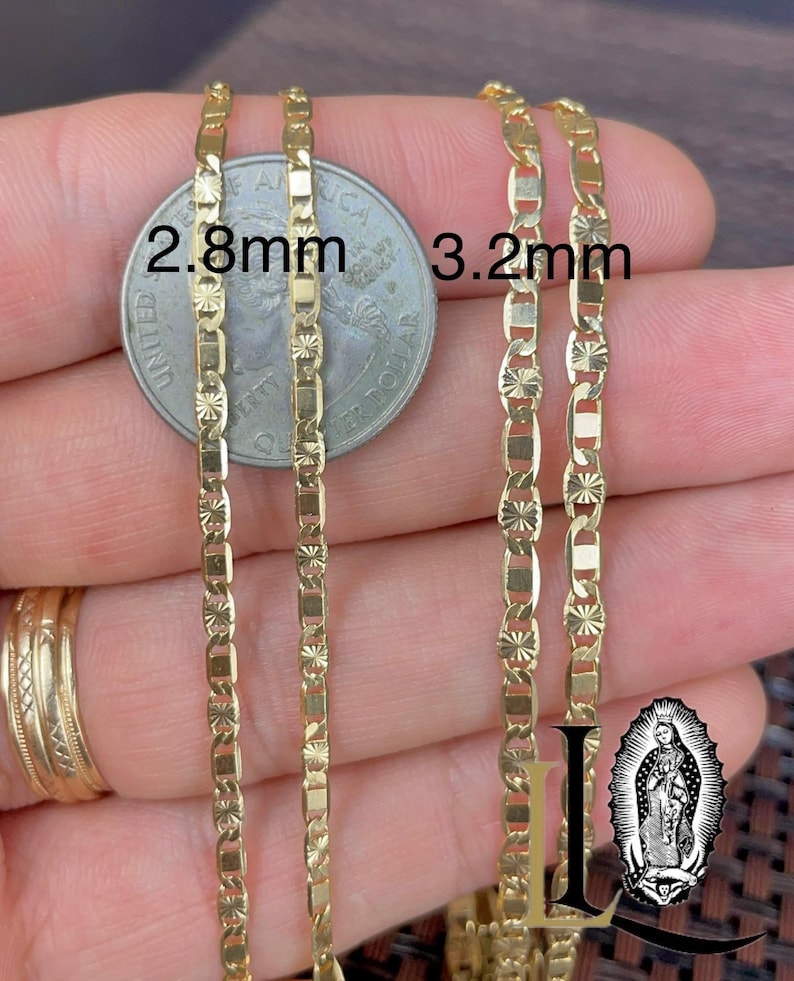 May include: Two gold-colored chain necklaces, 2.8mm and 3.2mm wide, are displayed. The chains have a repeating pattern of rectangular and starburst-shaped links. A US quarter is placed between the chains for size comparison. The image also includes a logo.