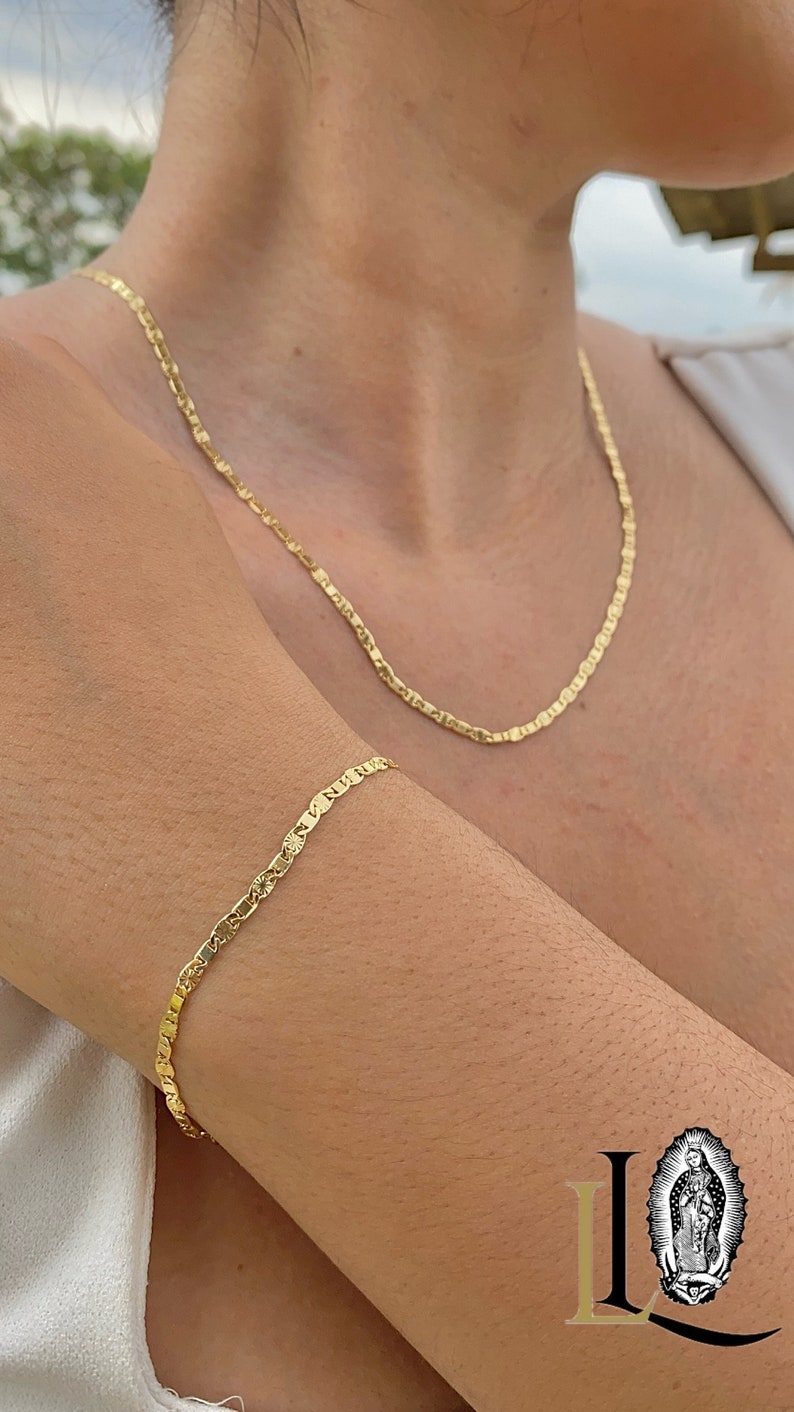 May include: A gold chain necklace and bracelet with a delicate, textured design. The necklace is worn around the neck and the bracelet is worn on the wrist.