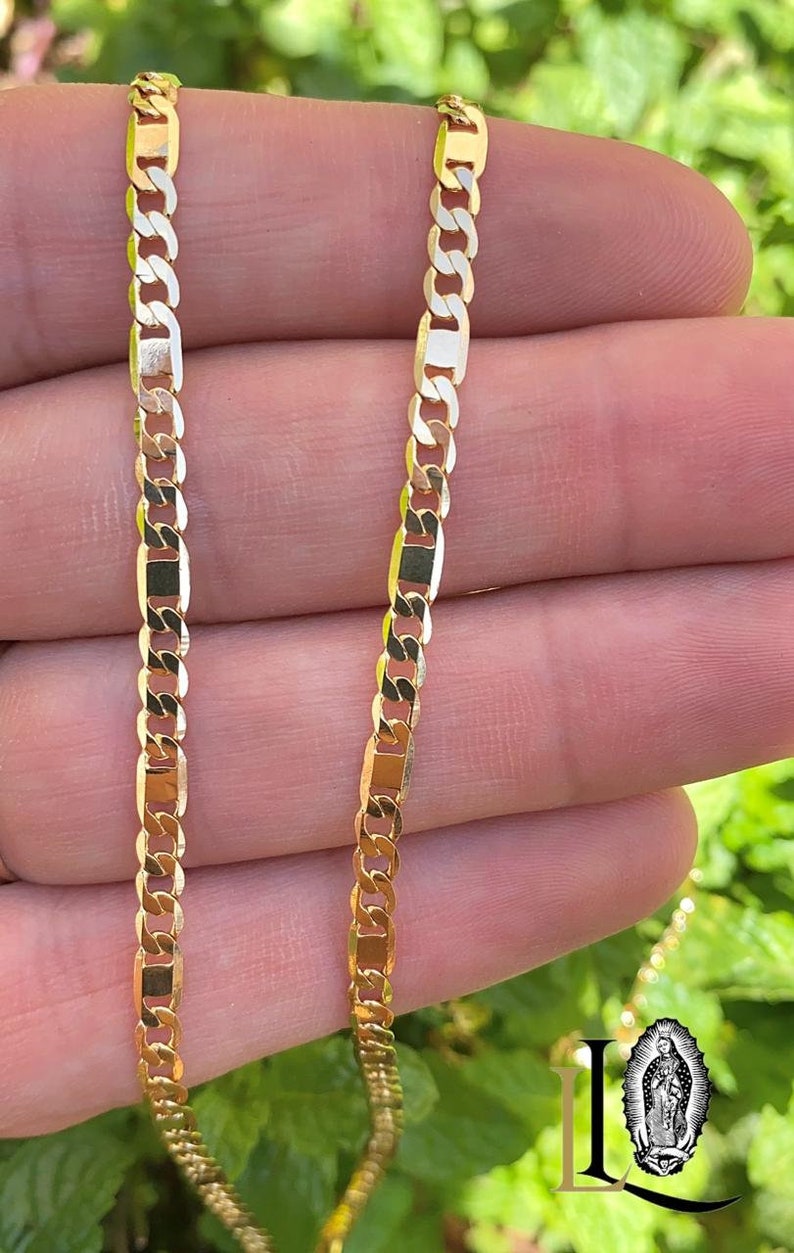 May include: A gold chain necklace with a curb link design. The chain is made of solid gold and has a polished finish.