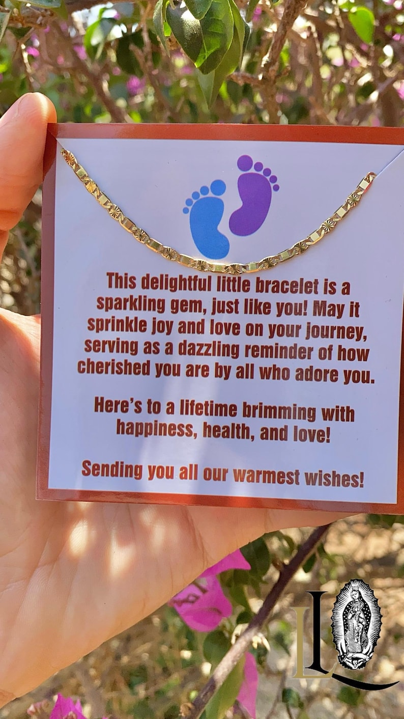 May include: A gold chain bracelet with a delicate design. The bracelet is displayed on a card with a message that reads: "This delightful little bracelet is a sparkling gem, just like you! May it sprinkle joy and love on your journey, serving as a dazzling reminder of how cherished you are by all who adore you. Here's to a lifetime brimming with happiness, health, and love! Sending you all our warmest wishes!"