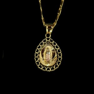 Puede incluir: Collar con colgante dorado que presenta un icono religioso dentro de un marco en forma de l&aacute;grima. El marco est&aacute; adornado con recortes en forma de coraz&oacute;n. La cadena y el colgante son de metal brillante y dorado.
