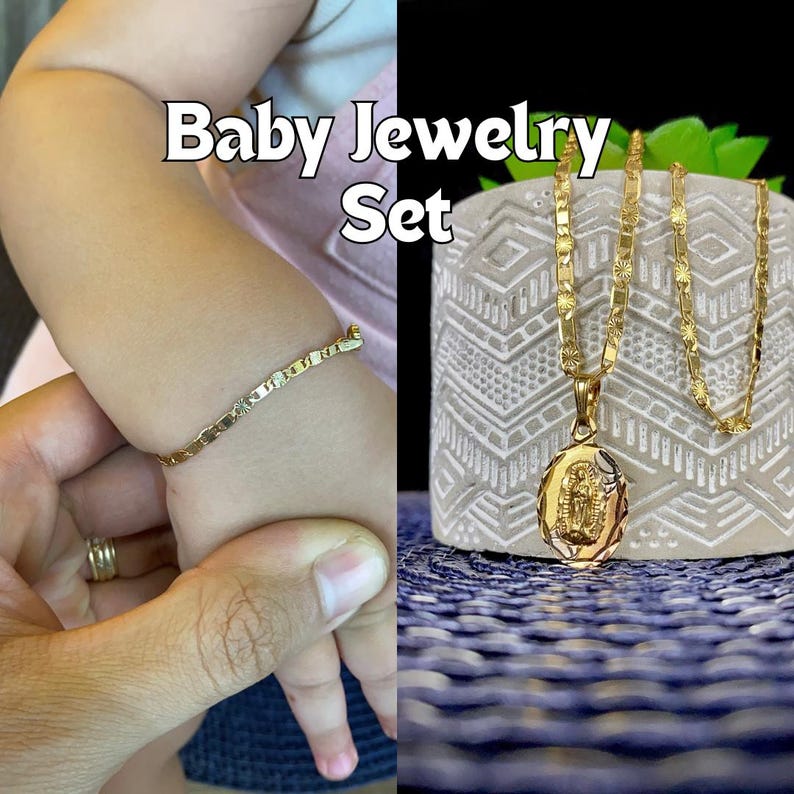 May include: A gold baby jewelry set with a bracelet and a necklace with a pendant featuring a religious image. The set is displayed on a white surface with a blue and white patterned background.