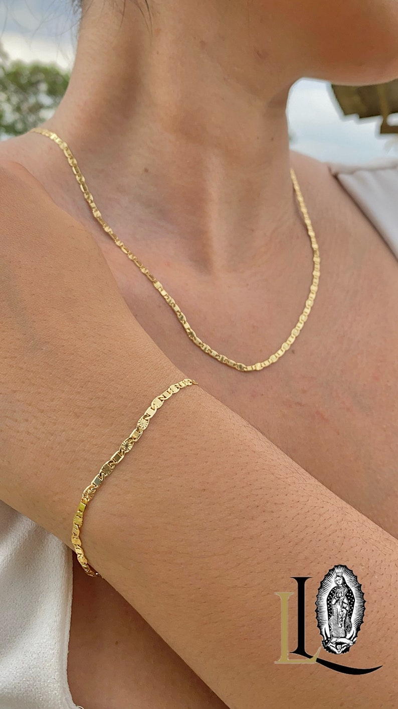 May include: A gold chain necklace and bracelet with a delicate, patterned design. The necklace is worn around the neck and the bracelet is worn on the wrist.